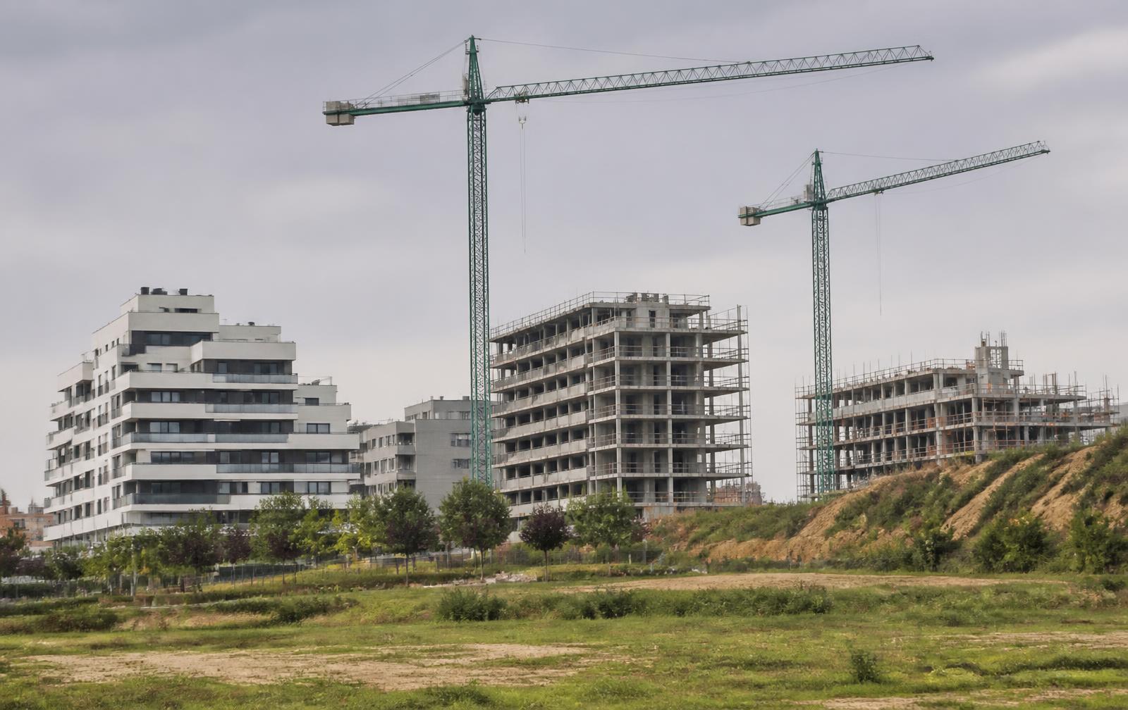 Promoción residencial en construcción en el entorno de Madrid, con grúas y bloques ya terminados al lado